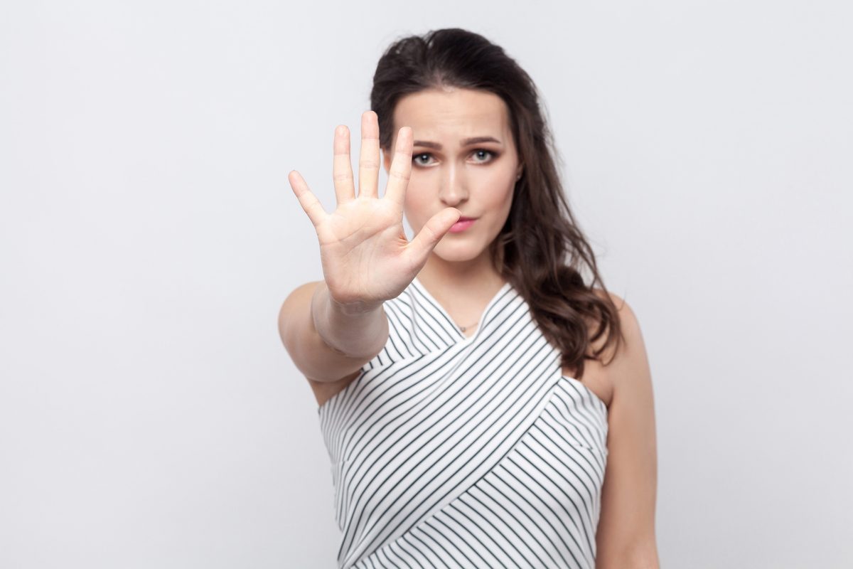 A woman holding up her hand in a stop gesture